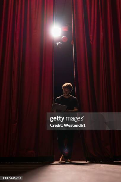 barefoot actor walking on stage of theatre studying script - actor script stock pictures, royalty-free photos & images