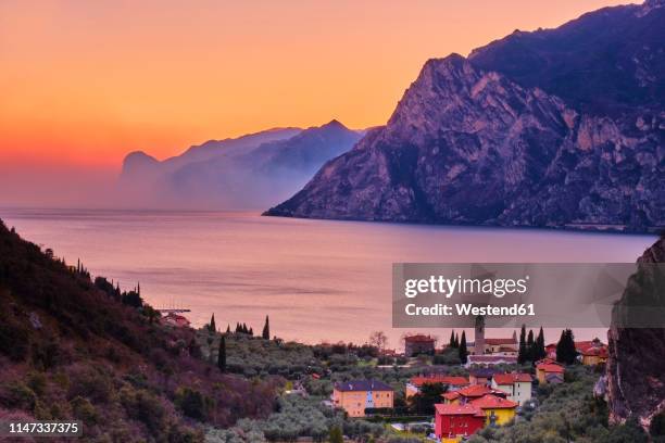 italy, torbole, view to lake garda at sunset - torbole stock pictures, royalty-free photos & images