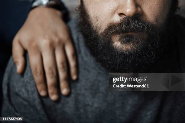 bearded man with boyfriend's hand on his shoulder, partial view - hand on shoulder stock pictures, royalty-free photos & images