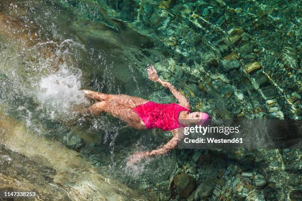 switzerland, ticino, verzasca valley, woman swimming in refreshing verszasca river - backstroke fotografías e imágenes de stock