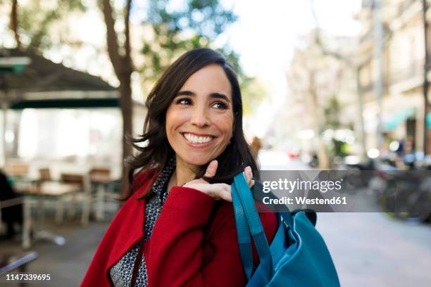 portrait of happy woman in the city - bolso rojo fotografías e imágenes de stock