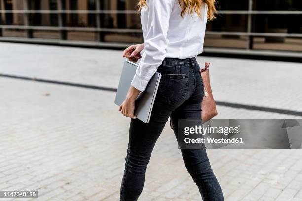 young businesswoman walking in the city, carrying laptop - woman carrying stock pictures, royalty-free photos & images