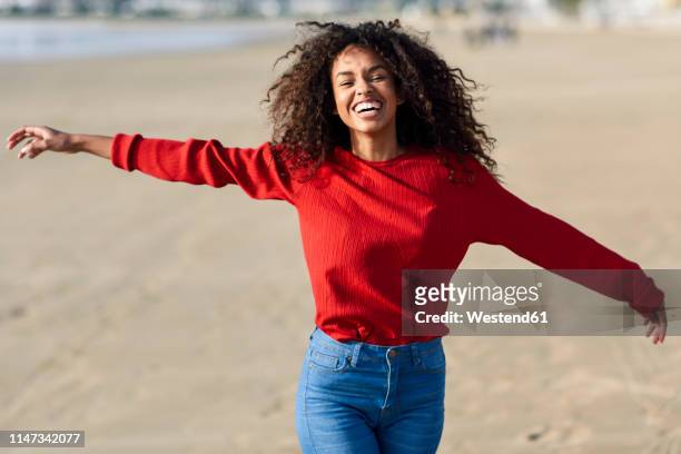 portrait of laughing young woman on the beach - wear red day - fotografias e filmes do acervo