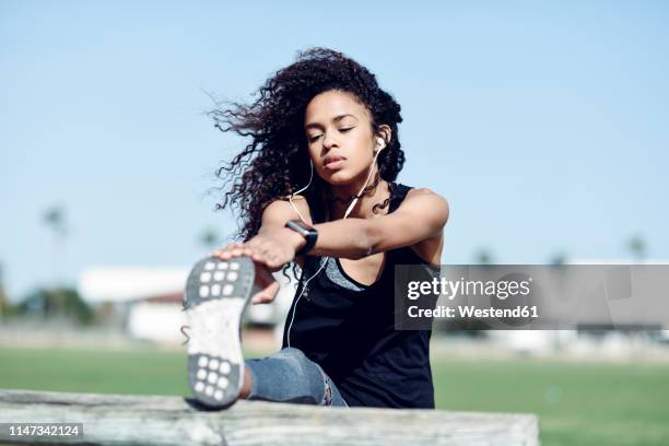 sporty young woman stretching outdoors - ropa de deporte fotografías e imágenes de stock