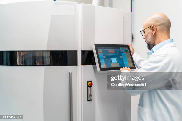 technician wearing lab coat operating 3d printer - 3d printen factory stockfoto's en -beelden