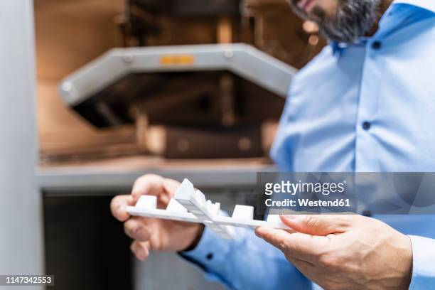 close-up of man holding workpiece at 3d printer - modern business people close up stock-fotos und bilder