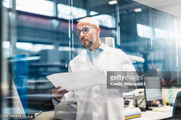 man wearing lab coat holding plan - modern laboratory stock pictures, royalty-free photos & images