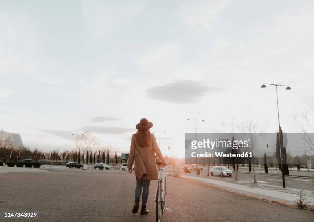 young hipster woman going with a bicycle during sunset - zaragoza city - fotografias e filmes do acervo