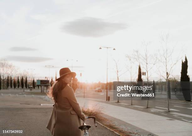 young hipster woman going with a bicycle during sunset - zaragoza city - fotografias e filmes do acervo