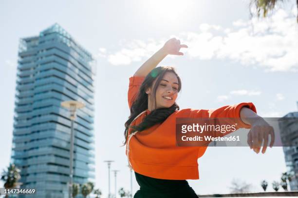 young contemporary dancer wearing red hoodie shirt, practicing her passion - 女性　ダンス ストックフォトと画像
