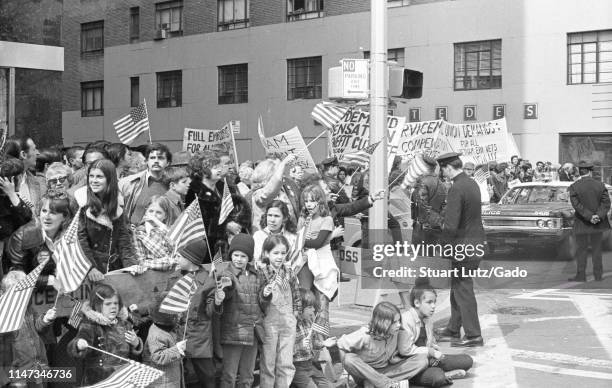 Spectators wave American flags and demonstrators hold banners during the Vietnam War-related Home With Honor Parade, New York City, New York, March...