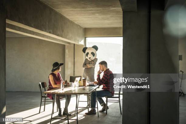 woman with panda mask watching colleagues in office - bear suit 個照片及圖片檔