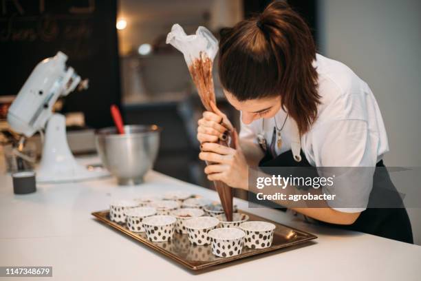 woman cooking cupcakes - action cooking stock pictures, royalty-free photos & images
