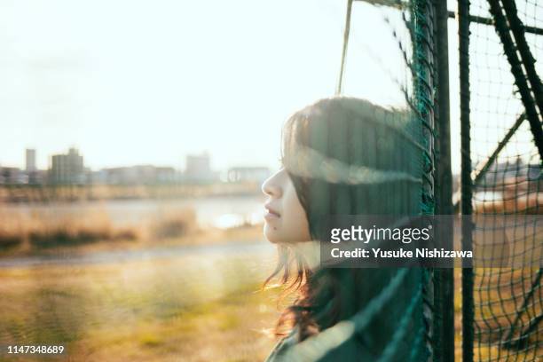 girl looking at a distance - baseball cage stock pictures, royalty-free photos & images