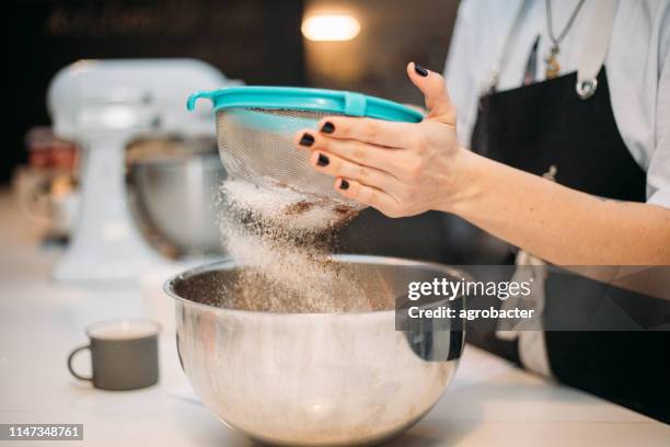 farine de tamisage de mains de femme - passoire photos et images de collection