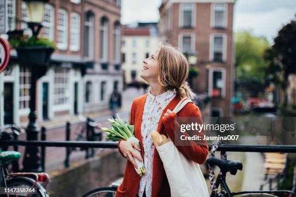 dutch woman with tulips - tulips amsterdam stock pictures, royalty-free photos & images