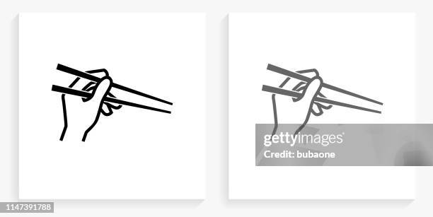 stockillustraties, clipart, cartoons en iconen met hand holding eetstokjes zwart en wit vierkant pictogram - eetstokje