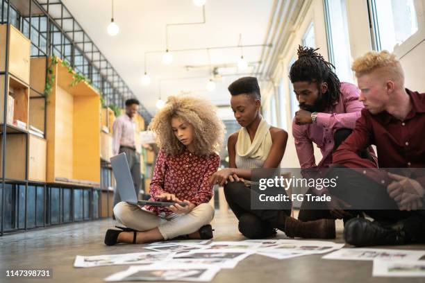 business team discussing some papers on the floor in the office - media press conference stock pictures, royalty-free photos & images
