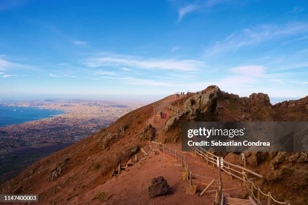 the summit crater with tourists walking over the steps by the mt. vesuvius volcano, gulf of naples, italy. - vesuvius ストックフォトと画像