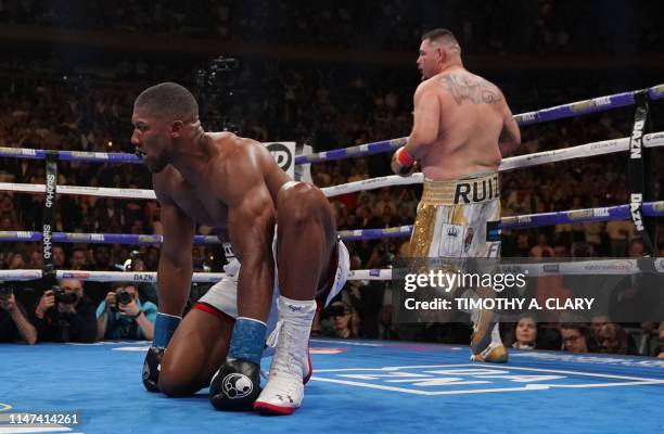 England's Anthony Joshua kneels after being knocked down by USA's Andy Ruiz in the 7th round to win by TKO during their 12-round IBF, WBA, WBO & IBO...