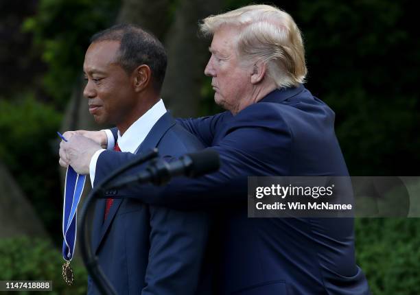 President Donald Trump presents professional golfer and business partner Tiger Woods with the Medal of Freedom during a ceremony in the Rose Garden...