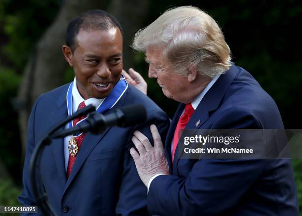 President Donald Trump presents professional golfer and business partner Tiger Woods with the Medal of Freedom during a ceremony in the Rose Garden...