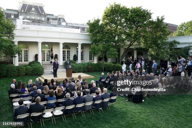 President Donald Trump listens as professional golfer and business partner Tiger Woods makes brief remarks after receiving the Medal of Freedom...