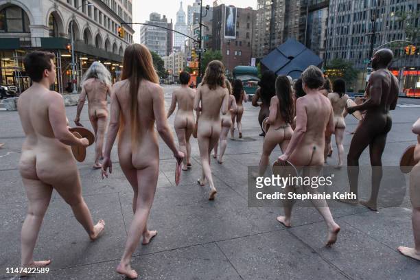 People prepare to pose nude holding cut outs of nipples during a photo shoot by artist Spencer Tunick on June 2, 2019 in New York City. Spencer...
