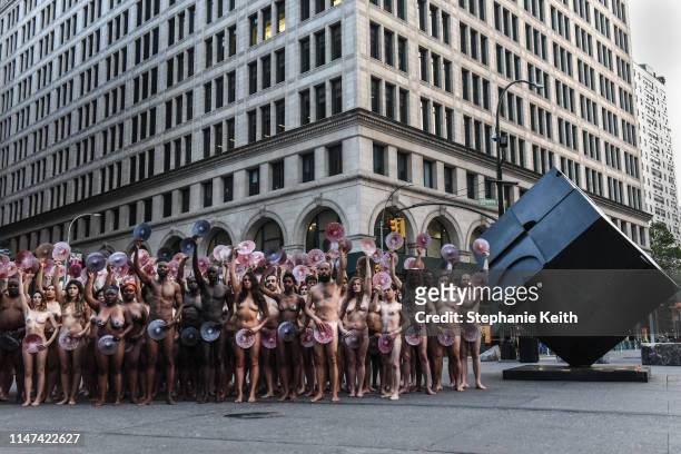 People pose nude holding cut outs of nipples during a photo shoot by artist Spencer Tunick on June 2, 2019 in New York City. Spencer Tunick staged...
