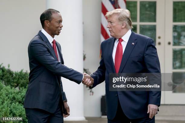 President Donald Trump gives professional golfer and business partner Tiger Woods the Medal of Freedom during a ceremony in the Rose Garden at the...