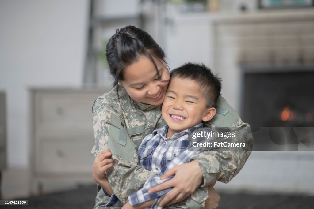 Mamá militar abrazando a su hijo