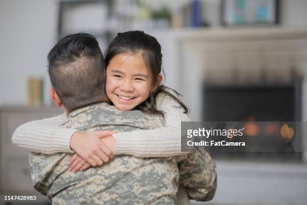 papà militare che abbraccia la sua giovane figlia - filipino family reunion foto e immagini stock
