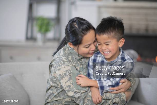 military mom hugging her son - filipino family reunion stock pictures, royalty-free photos & images