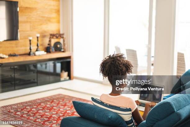 teenage girl studying on laptop in living room - student behind laptop stock pictures, royalty-free photos & images