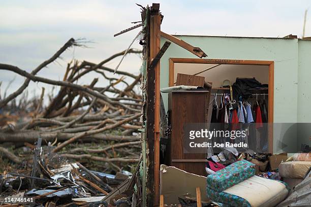 Clothes are seen hanging in a closet inside a destroyed house after it was destroyed when a massive tornado passed through the town killing at least...