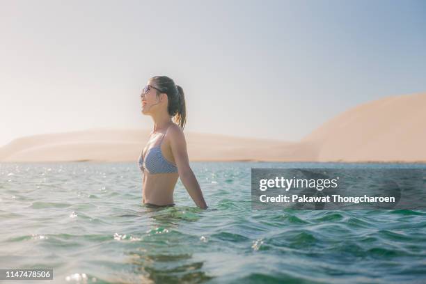 portrait of cheerful young woman in lagoon, lencois maranhenses national park, brazil - barreirinhas stock pictures, royalty-free photos & images