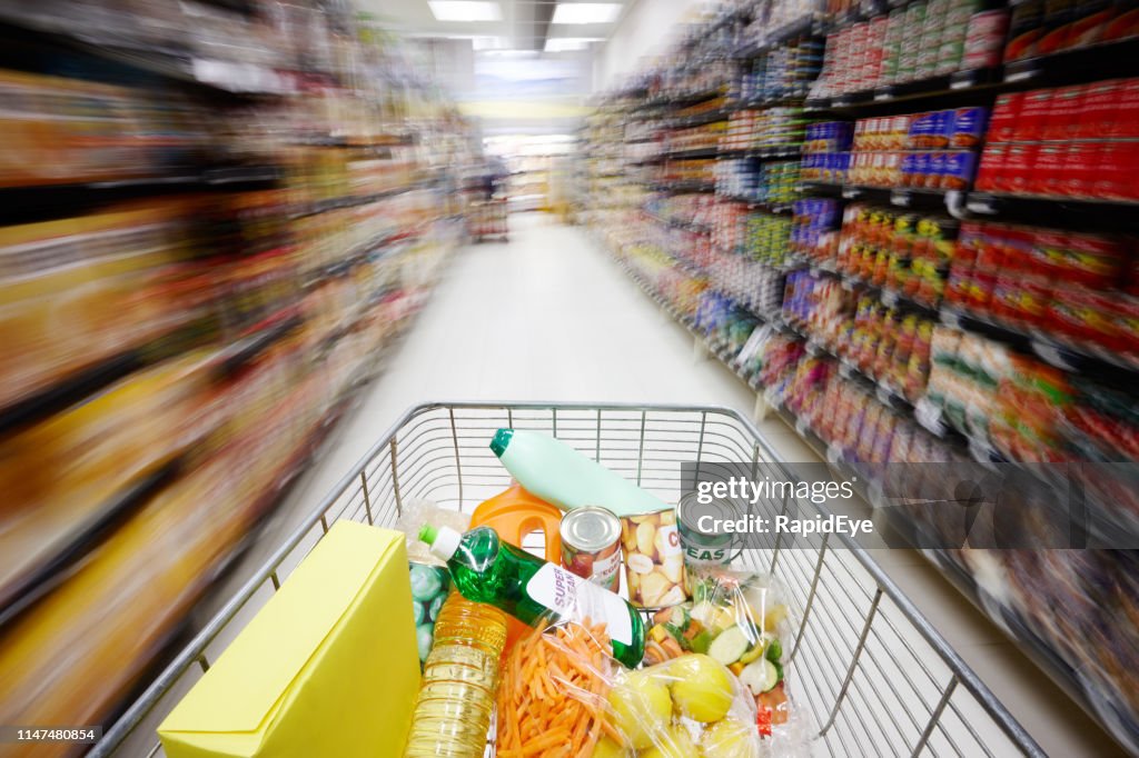 Shopping cart speeding down supermarket aisle creating motion blur