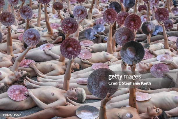 People pose nude holding cut outs of nipples during a photo shoot by artist Spencer Tunick on June 2, 2019 in New York City. Spencer Tunick staged...