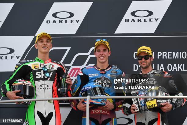 Moto2 category race winner Spain's Alex Marquez celebrates on the podium with runner-up Italy's Luca Marini and third-placed Switzerland's Thomas...