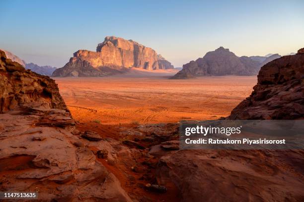 sunrise scene of red sand dune and amazing rock in wadi rum desert, jordan - jordanian stock-fotos und bilder