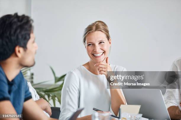 smiling businesswoman with coworkers in meeting - copenhagen people stock pictures, royalty-free photos & images