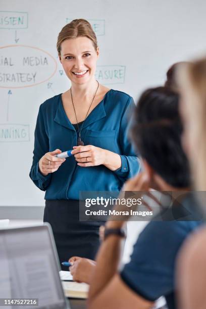 smiling businesswoman discussing with colleagues - denmark business stock pictures, royalty-free photos & images