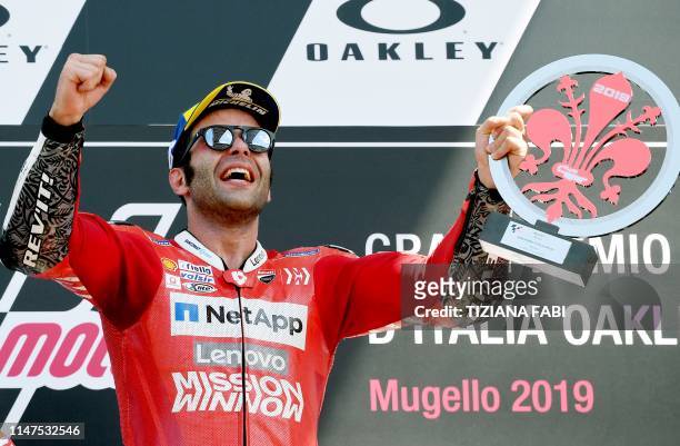 Italy's Danilo Petrucci holds his trophy as he celebrates on the podium after winning the Italian Moto GP Grand Prix at the Mugello race track on...