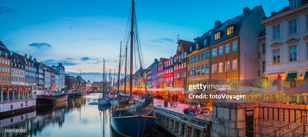 Copenhagen Nyhavn harbour restaurants cafes warmly illuminated sunset panorama Denmark