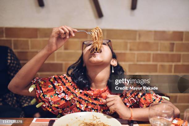 tweenage girl eating noodles - noodle stock pictures, royalty-free photos & images