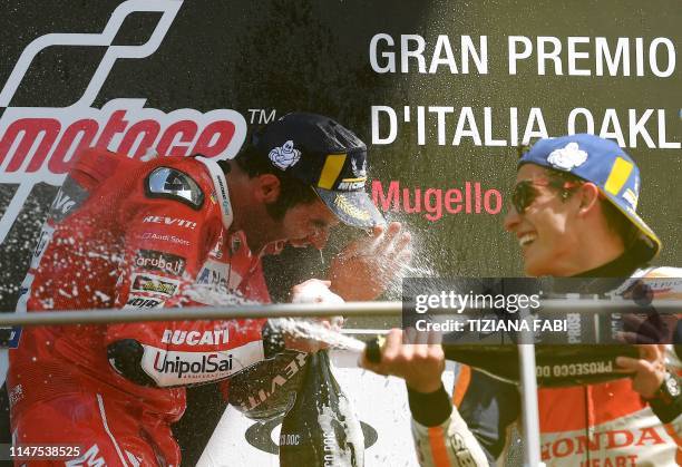 Race winner Italy's Danilo Petrucci and runner-up Spain's Marc Marquez spray champagne as they celebrate on the podium after the Italian Moto GP...