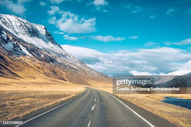 beautiful relax scenic view of the road with snow and mountain background in winter season , amazing view of road trip around iceland. - iceland mountains stock pictures, royalty-free photos & images