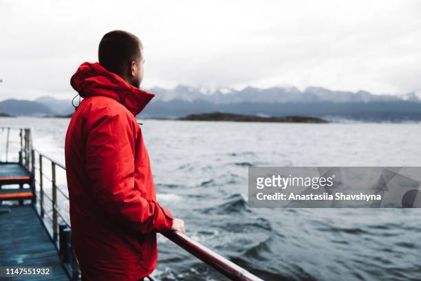 mann erkundet beagle-kanal in ushuaia mit kreuzfahrtschiff - ushuaia stock-fotos und bilder