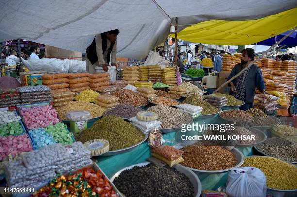 An Afghan vendor sells dry fruits and sweets ahead of the Eid al-Fitr festival, which marks the end of Islamic holy month of Ramadan, at a roadside...