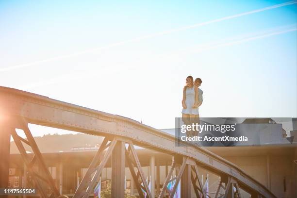 paarer spaziergang entlang der brücke bei sonnenuntergang - freiburg im breisgau stock-fotos und bilder